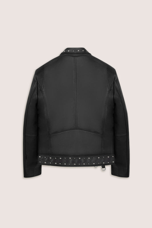 Back of a black leather biker jacket with studded details on a beige background