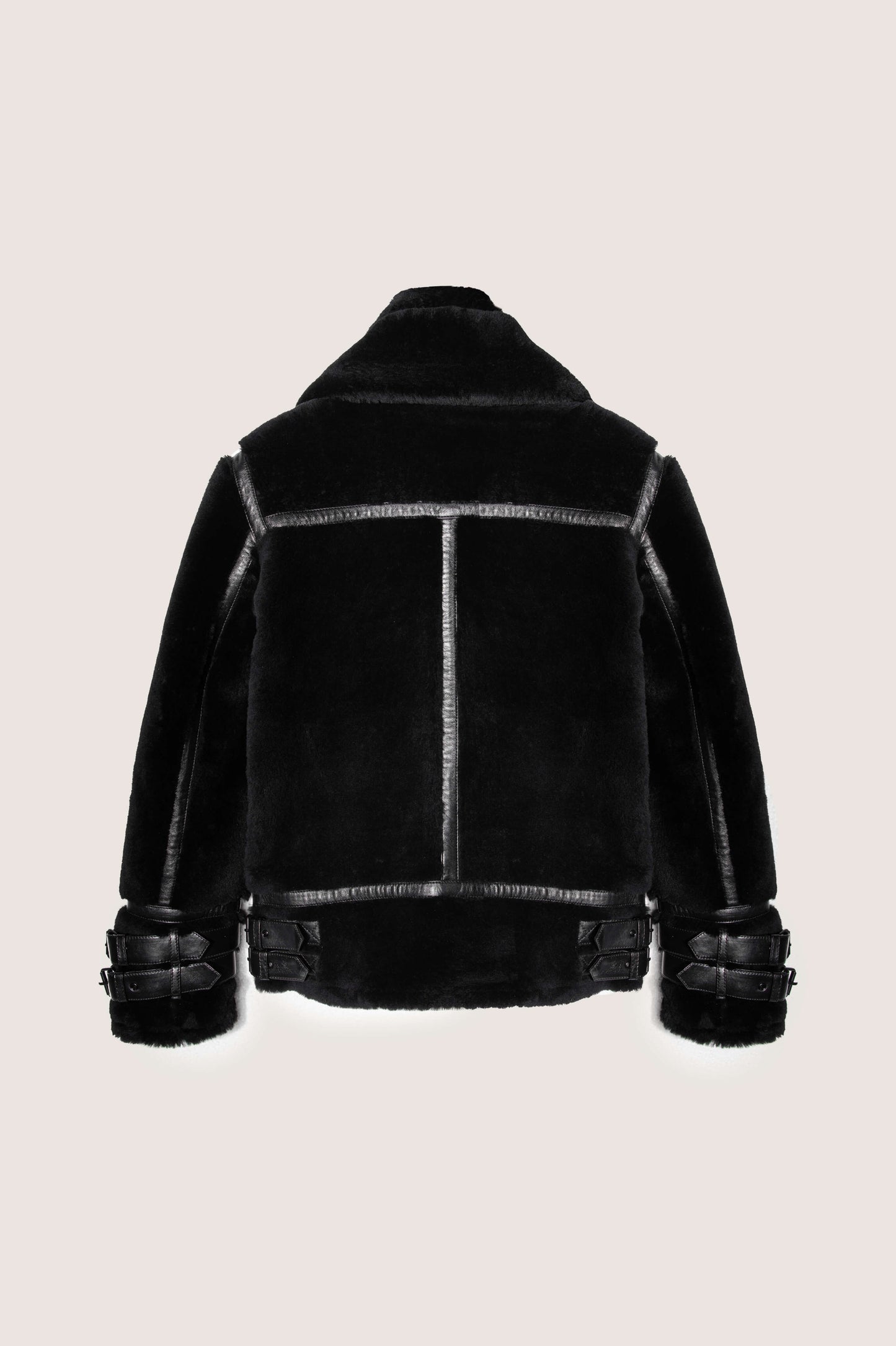 Black shearling jacket on a beige background
