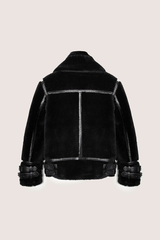 Black shearling jacket on a beige background